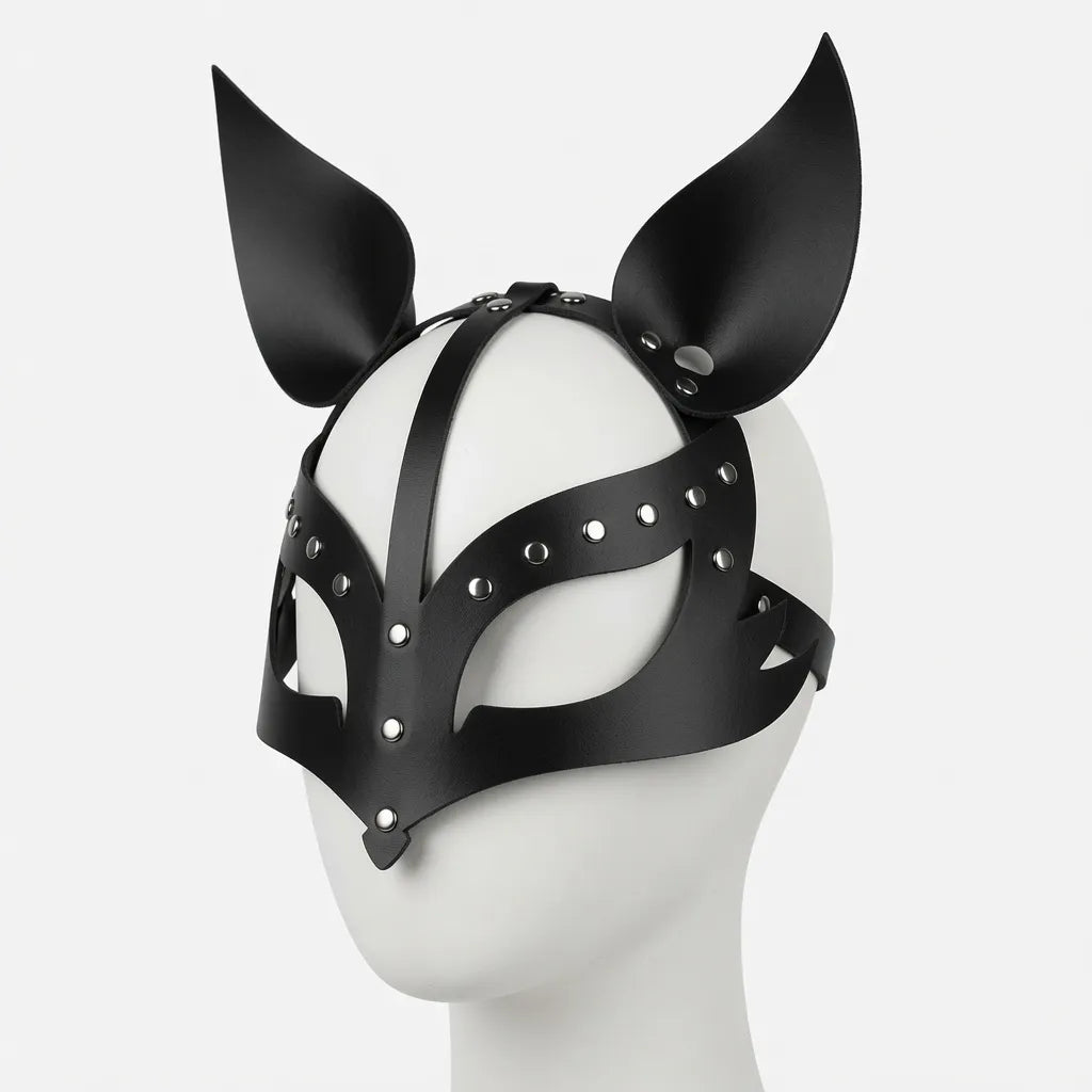 Masque de puppy play en cuir noir brillant de profil sur un mannequin, doté de lanières ajustables, de rivets argentés et d'oreilles de puppy pointues dressées pour le jeu de rôle animal, le petplay