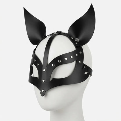 Masque de puppy play en cuir noir brillant de profil sur un mannequin, doté de lanières ajustables, de rivets argentés et d'oreilles de puppy pointues dressées pour le jeu de rôle animal, le petplay